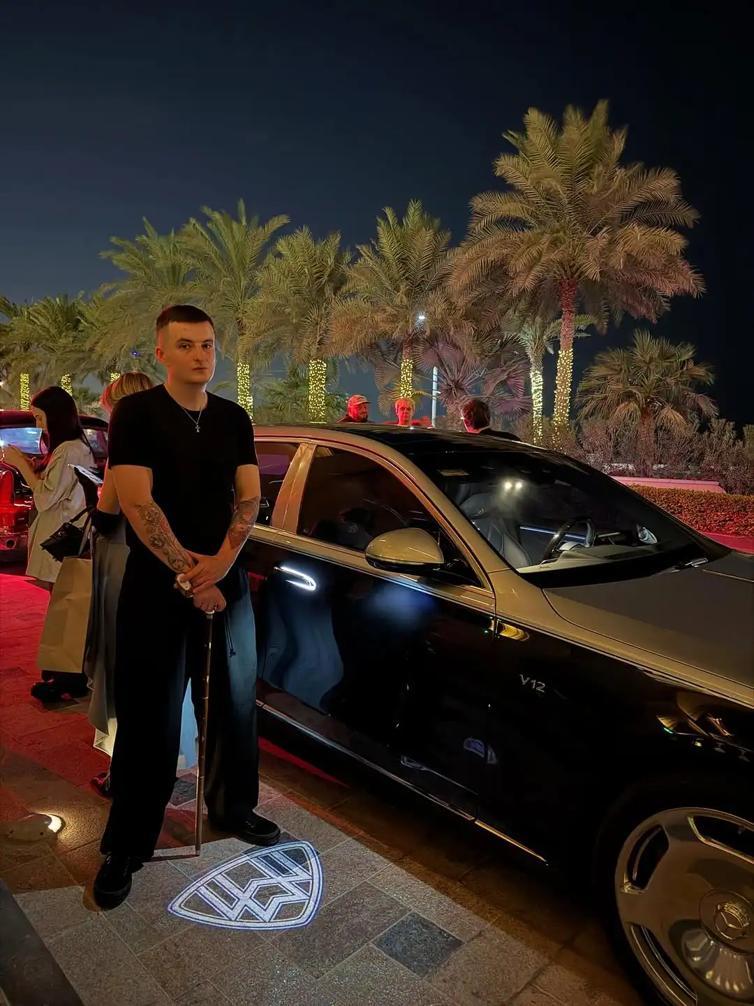 злой стример у дорогой машины с пальмами ночью